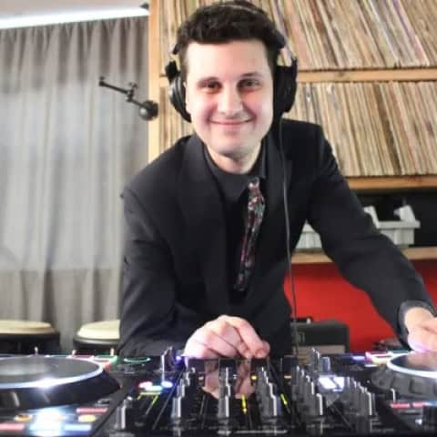 DJ Rusty Records wearing headphones and mixing music at a DJ controller