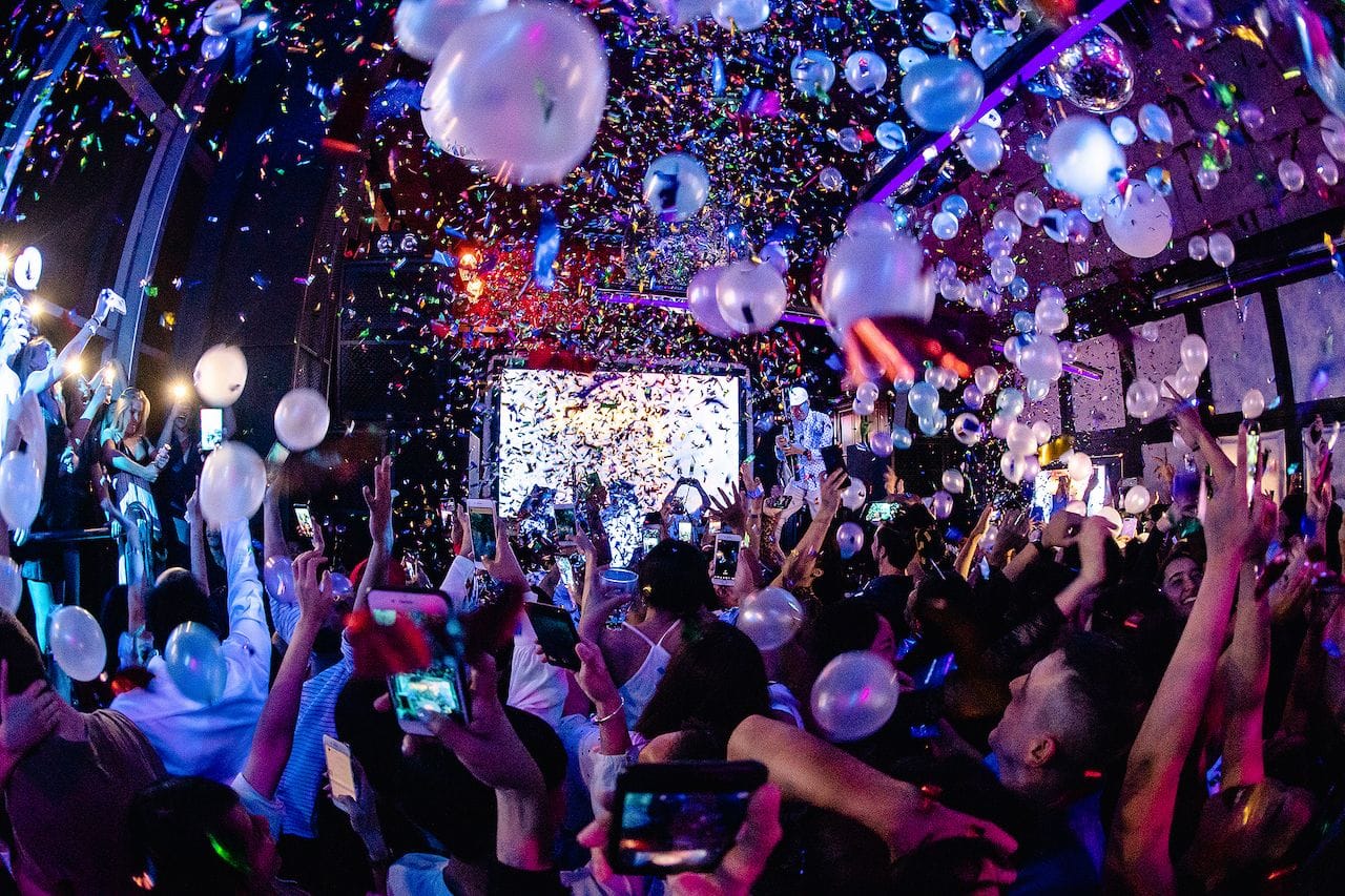 New Year's Eve party crowd celebrating under colorful lights